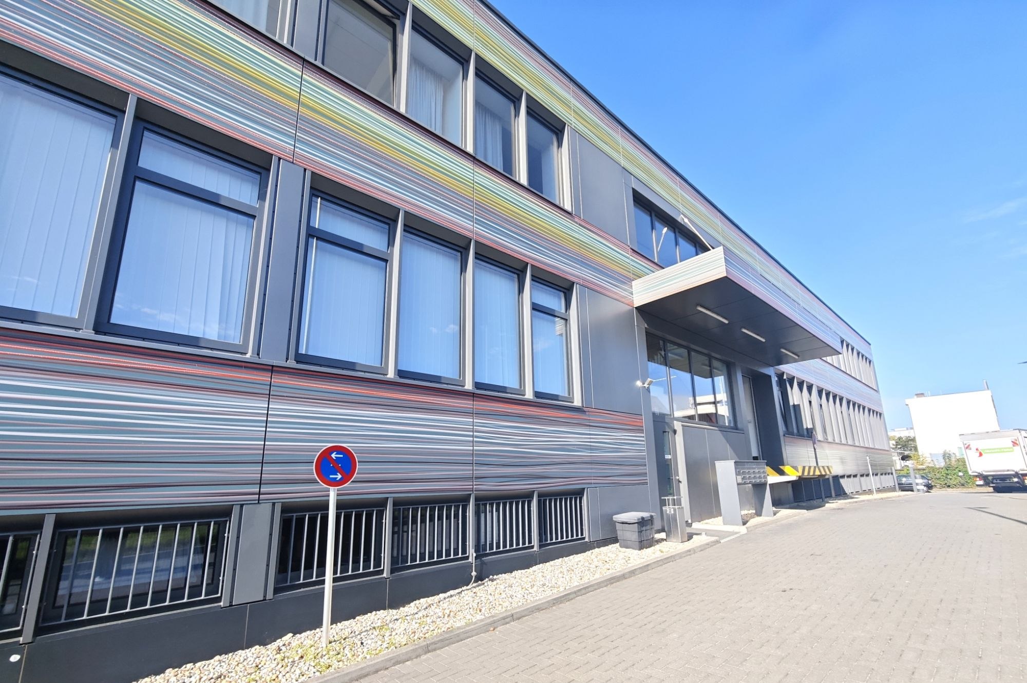 Gestreifte Fassade der Tuchfabrik Berlin mit Eingang und Vordach